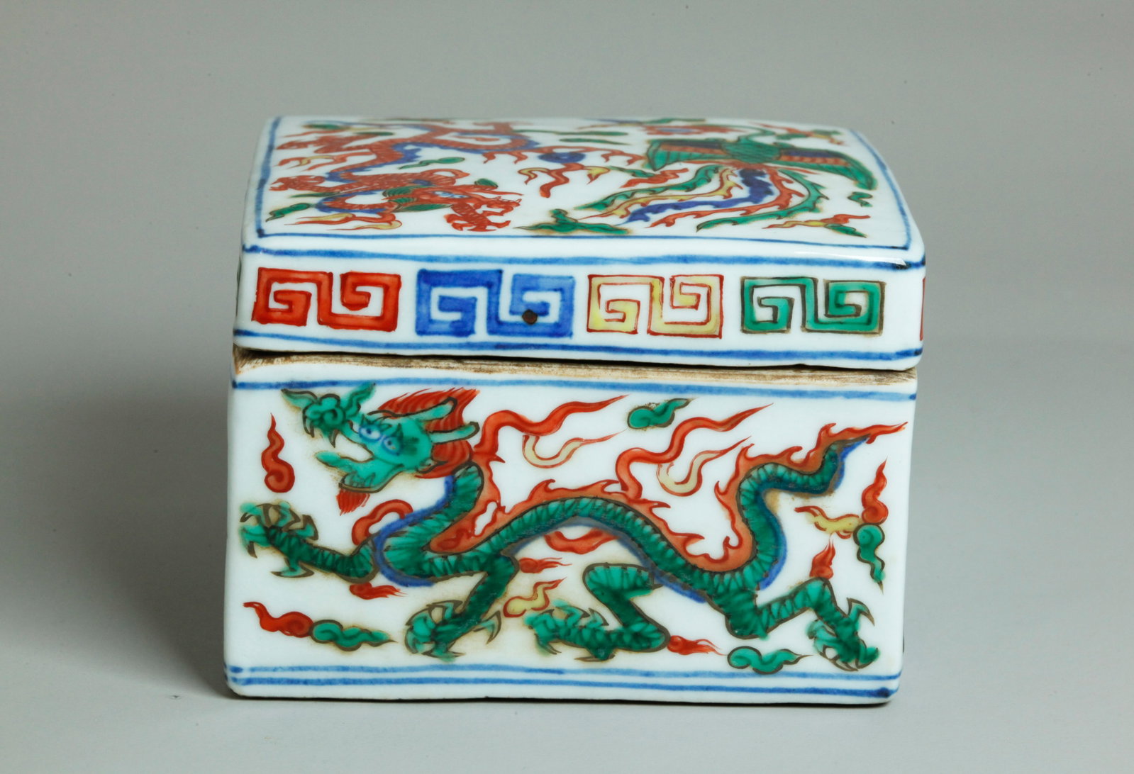 Chinese Wucai Enamel Porcelain Dragon Phoenix Box: Chinese Wucai Enamel on underglaze blue Porcelain rectangular Dragon & Phoenix Box; the flat base unglazed with a slightly recessed rectangle to center in clear glaze with horizontal 6 character