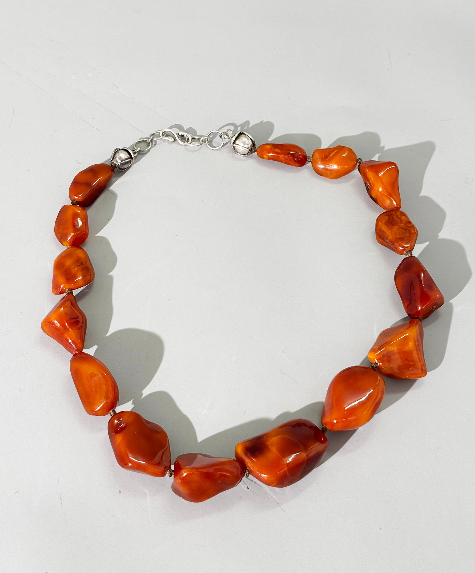15 Lg Butterscotch Amber Irregular Beads; 111.3G: 15 Large Butterscotch Amber Irregular polished Beads strung together to form a necklace; the "S" shaped hook closure with rings and balls in silver. Total weight 111.3 grams. Total length 24 1/2''