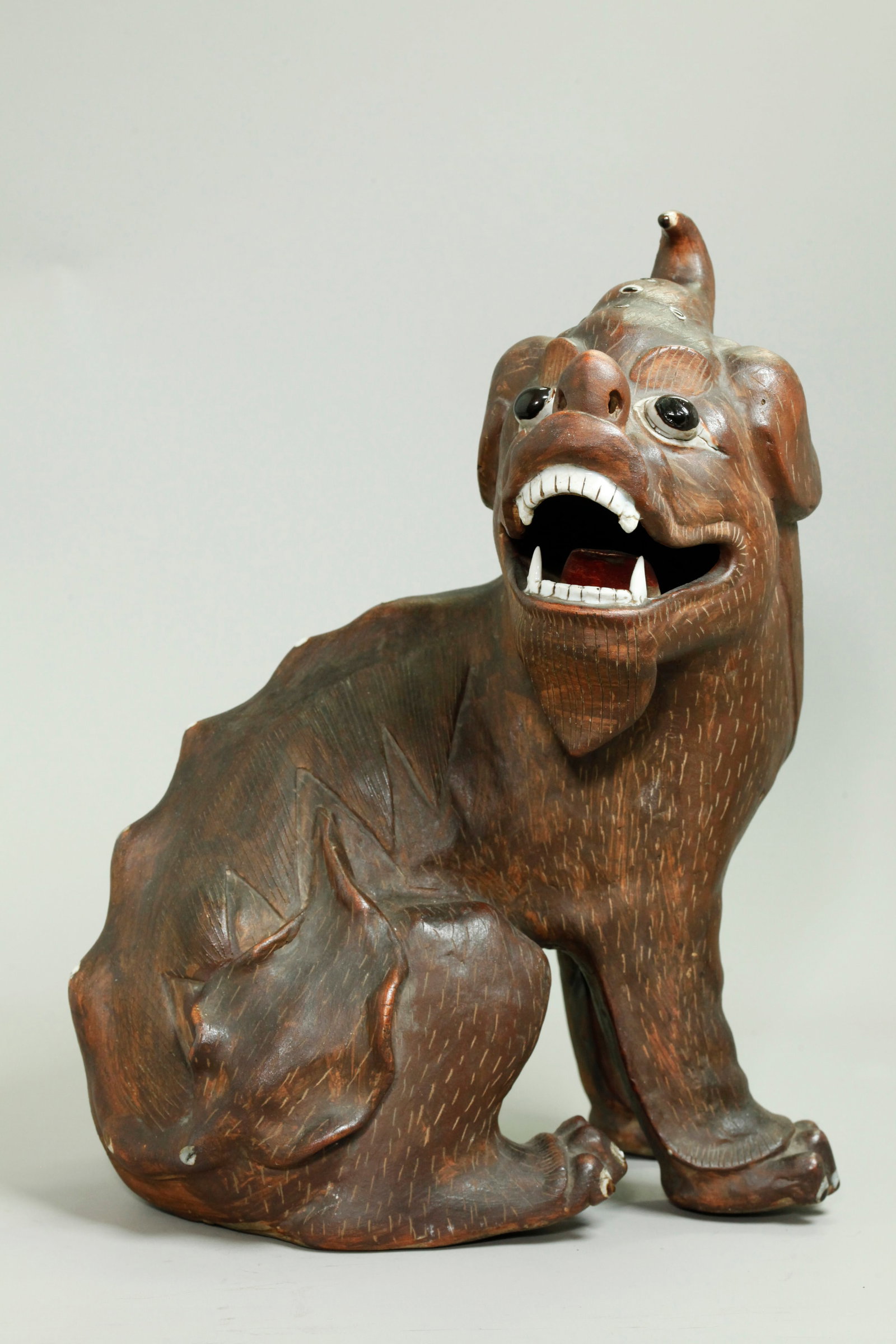 Lg Chinese Carved & Molded Porcelain Seated Qilin: Large Chinese Carved & Molded Porcelain Qilin seated on its haunches, mostly unglazed with incised fur marks and covered in a brown slip; with glaze to the white teeth, the black & white eyes, claws