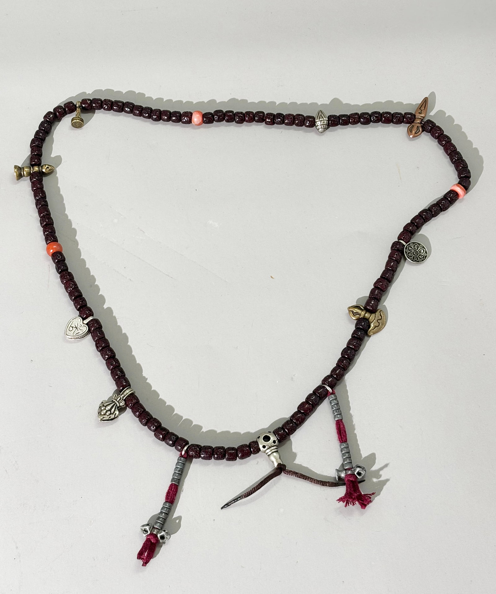 Tibetan Buddhist 108 Bodhi Seed Bead Rosary; 89G: Tibetan Buddhist 108 polished Bodhi Seed Bead Rosary with carnelian agate spacers, further sectioned with small bronze or silver metal amulets, Vajra, Phurba, etc. Total weight 89 grams. Length 36 inc