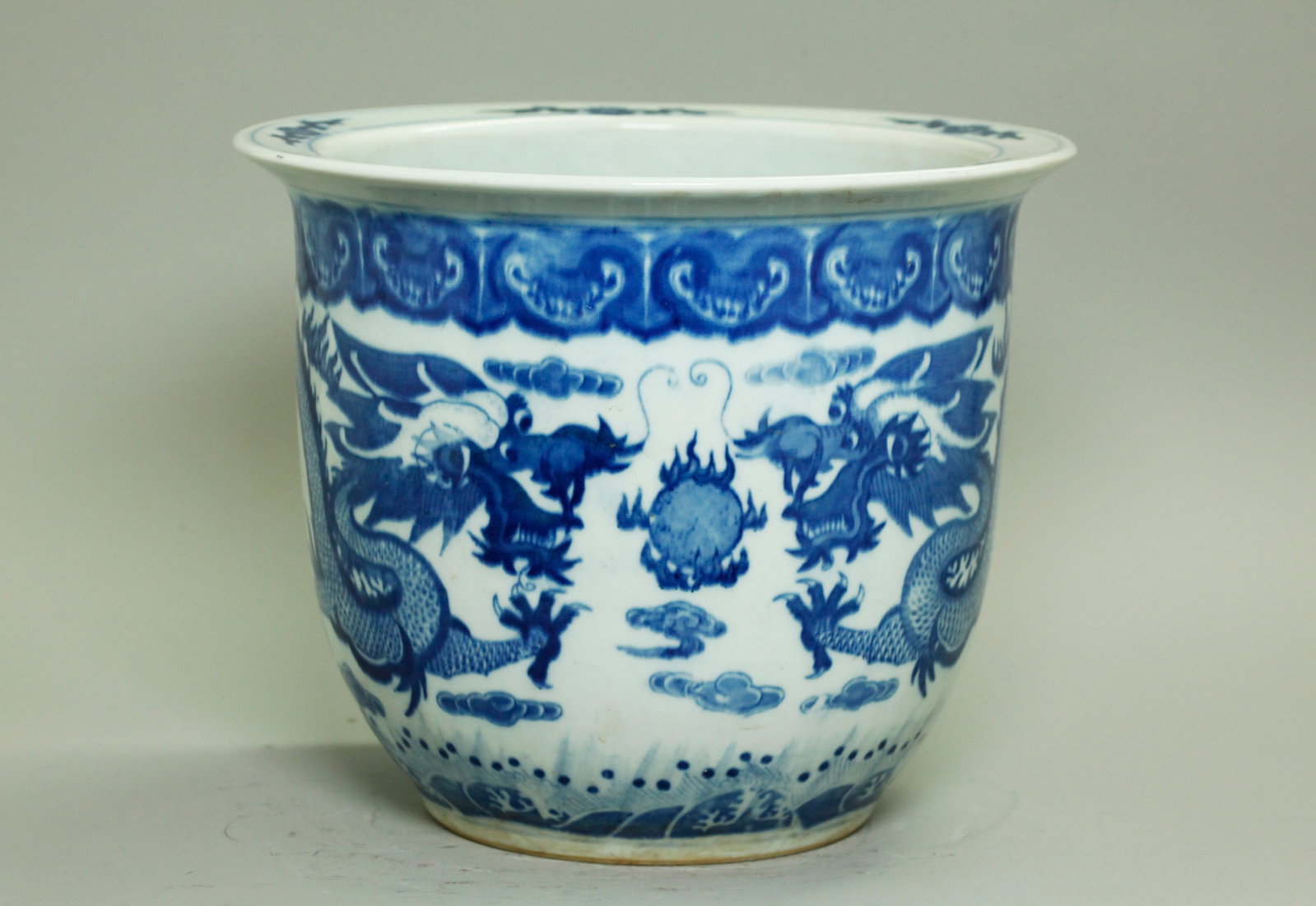 Chinese Blue White Dbl Dragon Porcelain Planter: Chinese round bowl shaped Blue & White Porcelain Planter with a design of double 5 claw Dragons facing a Flaming Pearl over a wave border at the bottom, with floral everted rim and original drainage h