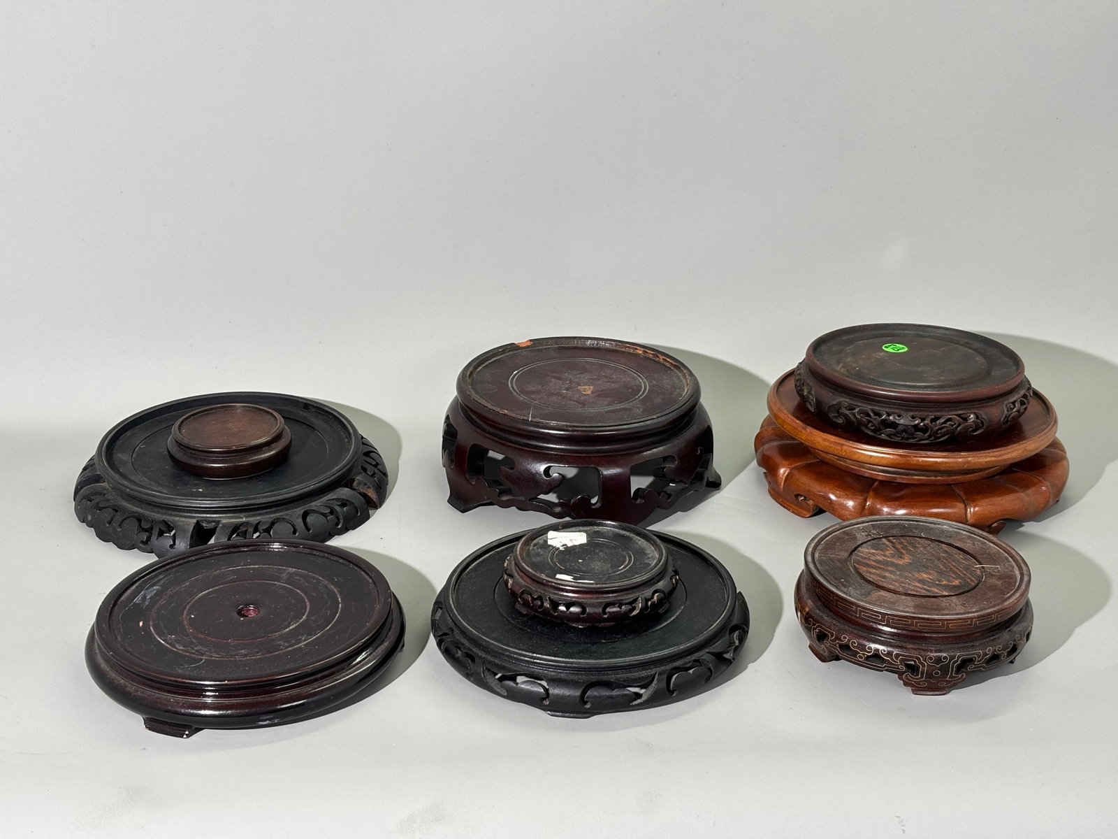 9 Chinese Round Hard Wood Stands; 6 Large: 9 Chinese Round Hard Wood Stands; 6 Large, 3 small including 1 with silver wire inlay. The inside top diameter of the largest 7 7/8 inches. The inside top diameter of silver wire stand 5 inches. See i