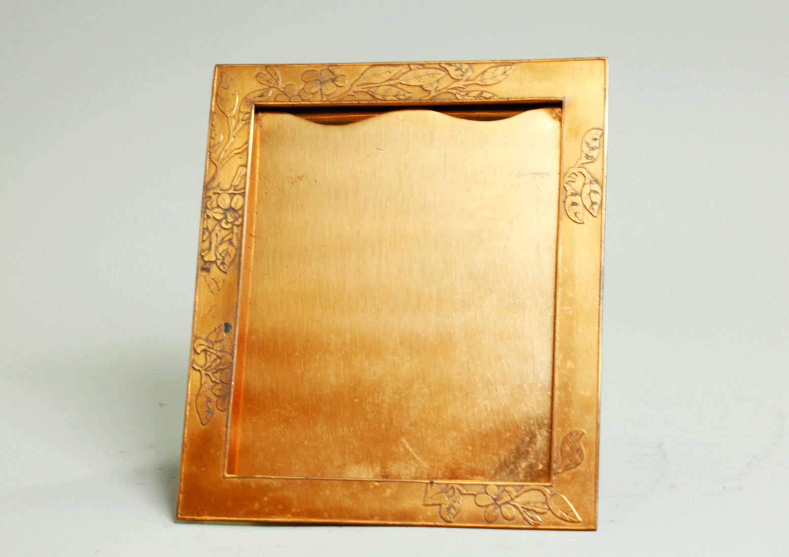Tiffany Engraving Dept Copper Strut Back Frame: Tiffany Engraving Department Copper Strut Back Frame with acid etched arts & crafts floral border to front, the back marked "Tiffany & Co Makers with the John C Moore II mark, 1907-1947; the strut mad