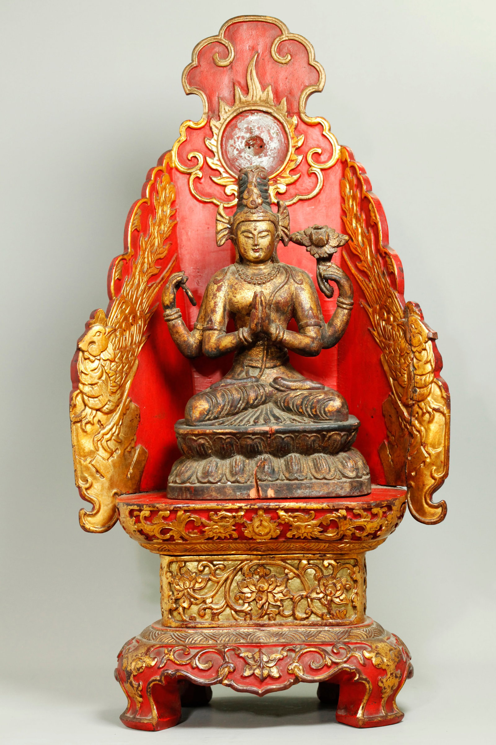 S E Asian Gilt Wood Avalokiteshvara & Throne: South East Asian Gilt Wood seated 4 armed Avalokiteshvara / Guanyin with loop rope and lotus all carved together on a double Lotus throne; together with a separate red & gilt wood stand on 4 feet atta