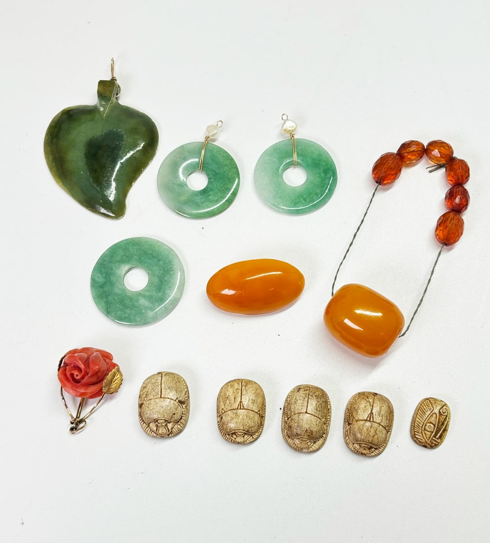 5 Scarabs Coral Rose 3 Jadeite Bi 8 Ambers: 5 Egyptian carved Scarabs, a Coral carved Rose set in yellow gold as a pendant, 3 lite green Jadeite Bi rings, 2 with yellow gold wire and Baroque Pearls, 8 Ambers, a butterscotch bead, an oval butter