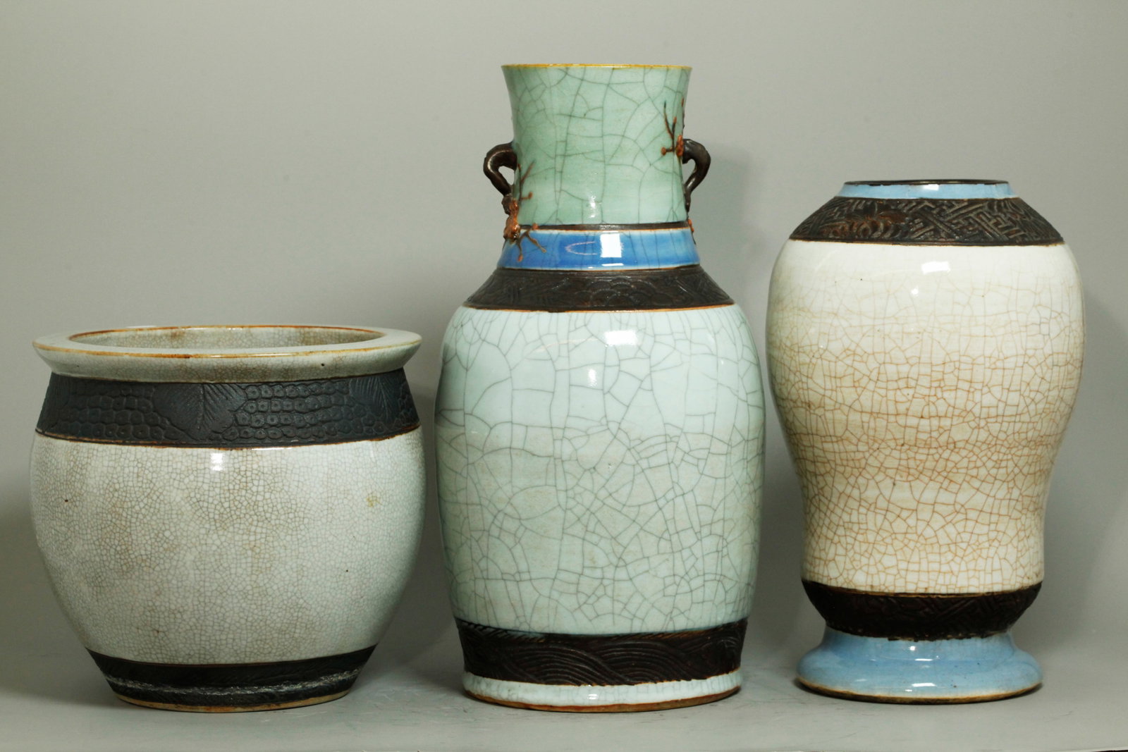 3 Chinese Qing Crackle & Brown Slip Porcelains: 3 Chinese Qing Dynasty Porcelains; 2 vases and 1 fish bowl, each in clear Crackle glaze with unglazed carved bands covered in Brown Slip, the 2 vases with additional bands of light blue crackle glaze,