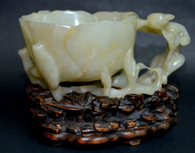 Good Ming Chinese Hetian Jade Carved Cup: Chinese Hetian Jade Carved Cup, Ming Dynasty, carved as a dragon surrounding a blossom. Original, intricately carved hardwood stand. From the collection of MRS. JOAN GROUBER. Height with stand 4 inche