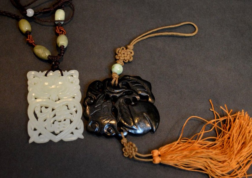 2 Chinese Carved Hardstone Pendants: 2 Chinese Carved Hardstone Pendants; the first of spinach jade carved with a bat and peach with an old silk tassel, good condition. Diameter 2 inches (5 cm.); the second of a white jade with pierced d