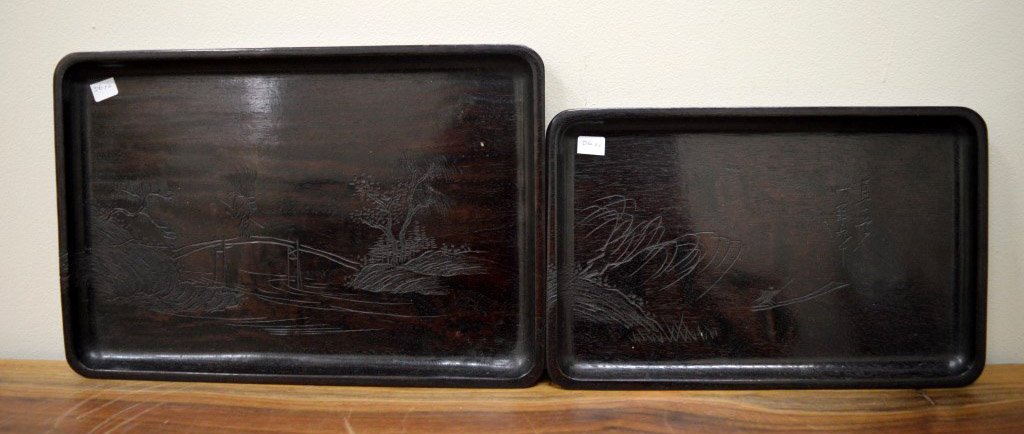 2 Asian Wood Carved Nesting Trays: 2 Asian Wood Carved Nesting Trays each incised with lines in the round to define land and seascapes. Width of larger 13 3/4 inches (35 cm.). Good Condition.