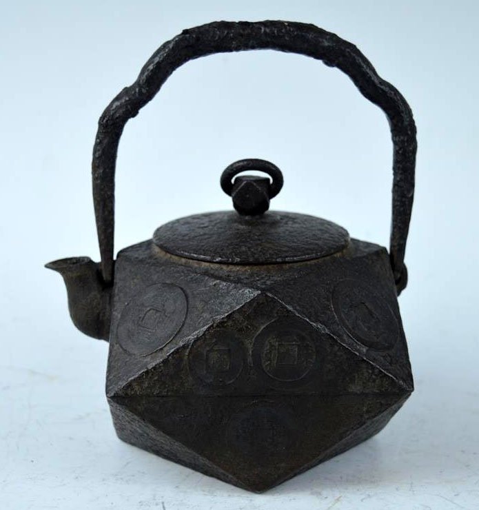 Geometric Japanese Iron Water Pot: Geometric Japanese Iron Water Pot with a design of coins on the surface, swing handle to pot and lid. Good condition. Height to top of handle 6 1/2 inches (16.5 cm.).
