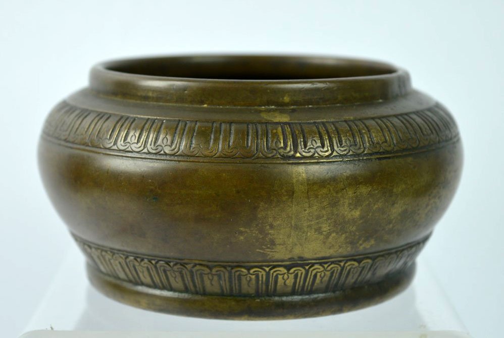 Chinese Incised Bronze Incense Burner: Chinese Incised Bronze Incense Burner, the sides with two rows of Buddhist petals and a flower centered on the base. Age related wear to the patina. Diameter 4 3/4 inches (12 cm.).
