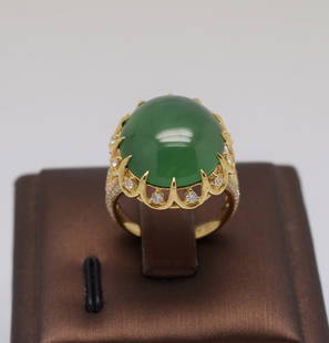 18K Gold Large Bright green jadeite diamond Ring: This artistically design 18K yellow gold diamond ring features a large bright green jadeite jade of high translucency and even coloration, measured at 19.41 x 15.91 x 7.83 mm at 18.6ct. The ring is