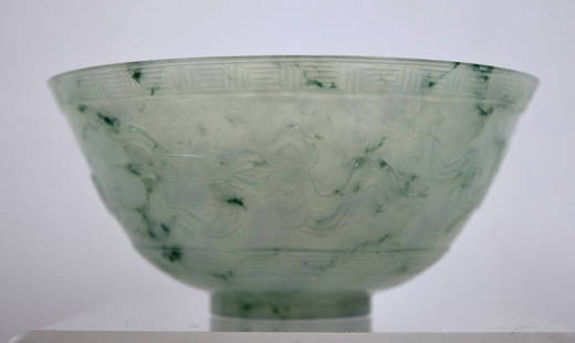 Chinese Carved Translucent Jadeite Bowl: Chinese Carved Translucent Jadeite Bowl, the pale light green translucent stone with even flecks of dark green, the sides carved with 4 Precious Objects between bands of clouds; good foot and