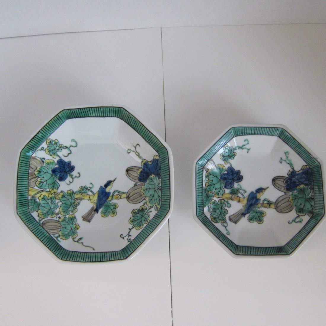 Pair of Kutani octagonal footed bowls hand painted with: Pair of Kutani octagonal footed bowls hand painted with birds and melons, signed at the bottom, good condition, 6” and 7” in diameter.