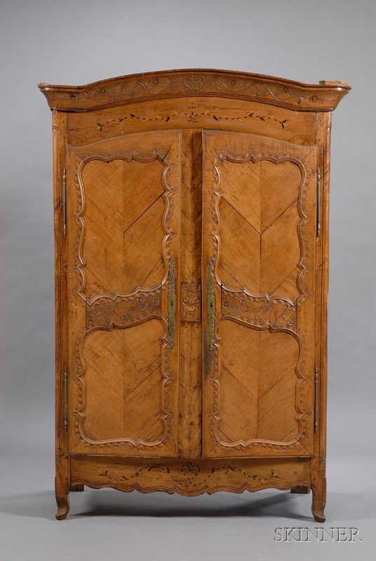 Louis XV Provincial Inlaid and Carved Fruitwood Ar: Louis XV Provincial Inlaid and Carved Fruitwood Armoire, 18th century, serpentine cornice above a pair of doors, on scrolled feet, carved with flowering vines, and rocaille, inlaid with leafy vines, h