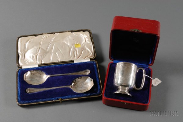 Two Cased George V Silver Tablewares, pair of serv: Two Cased George V Silver Tablewares, pair of serving spoons, Sheffield, 1915, lg. 8 1/2, and a mug, London, 1911, with ear handle and domed foot, engraved with floral swags, ht. 4 in., both in fitted