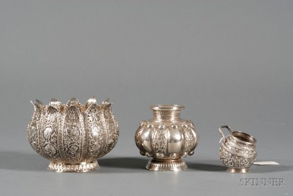 Three Indo-Persian Silver Tablewares, late 19th/ea: Three Indo-Persian Silver Tablewares, late 19th/early 20th century, a floriform bowl with crenellated and pierced rim, chased and embossed with foliate panels, ht. 3 7/8; a melon-shaped vase, chased a