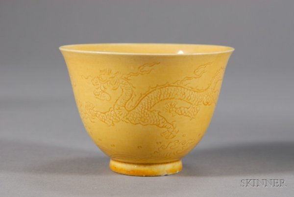 Yellow Porcelain Cup, China, 19th century, egg yo: Yellow Porcelain Cup, China, 19th century, egg yolk yellow color, engraved with dragons and clouds, dia. 3 1/2 in.