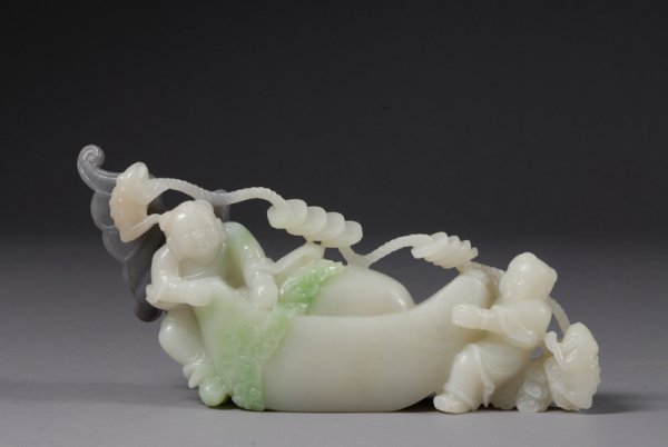 Jade Carving, white stone with areas of gray and : Jade Carving, white stone with areas of gray and green, carved as two children with a string of cash coins, a silver ingot, frogs, and bats, lg. 11 in.