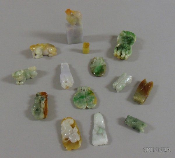 Fourteen Carved Jade Pendants and Other Items, in: Fourteen Carved Jade Pendants and Other Items, in various forms including a gray and red rooster stamp, a green and white foo dog pendant, a brown and white seated bull pendant, insects, vegetables, f
