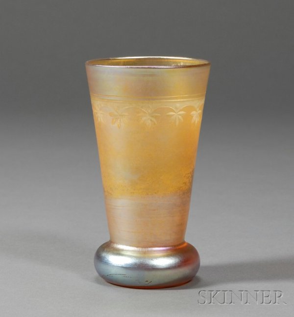 Tiffany Decorated Vase Favrile glass New York, ear: Tiffany Decorated Vase Favrile glass New York, early 20th century Tapered tumbler form with bulbous base in gold iridescent glass, decorated with a band of etched stylized leaves, polished pontil, ini