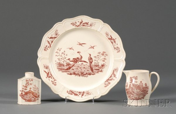 Three Red Transfer Printed Creamware Items, England: Three Red Transfer Printed Creamware Items, England, late 18th century, a serving dish with exotic bird border and central design, dia. 11 3/4 in.; jug with shepherd to one side and country lovers to