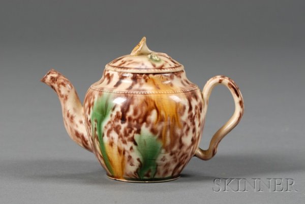 Staffordshire Tortoiseshell Glazed Creamware Teapo: Staffordshire Tortoiseshell Glazed Creamware Teapot and Cover, England, c. 1760, floral finial, ear-shaped handle, translucent brown with splashes of green and yellow, ht. 3 1/2 in.