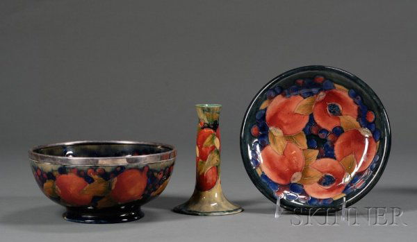 Three Moorcroft Pottery Pomegranate Items, England: Three Moorcroft Pottery Pomegranate Items, England, c. 1920, including a candle holder, ht. 6 in.; bowl with silver plated rim, dia. 8 in.; and a plate, dia. 8 1/2 in.; artist signed and impressed mar