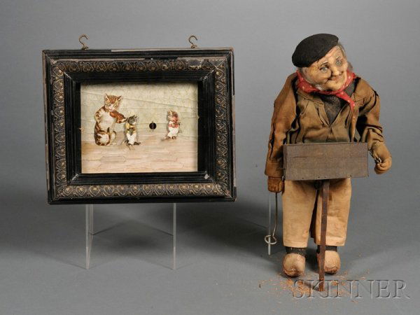 Two Musical Toys, a German picture automaton of th: Two Musical Toys, a German picture automaton of three (of four) dancing cats, 8 1/4 x 10 1/2; and a musical Ravca organ grinder doll, ht. 14 in., (both in need of restoration).