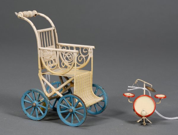 M?rklin Painted Steel Miniature Doll Stroller, ear: M?rklin Painted Steel Miniature Doll Stroller, early 20th century, cream vehicle with blue wheels and trim, ht. 5 3/4, (some damage on frame and wooden handle); and a red-trimmed drum set, 1/2-inch sc