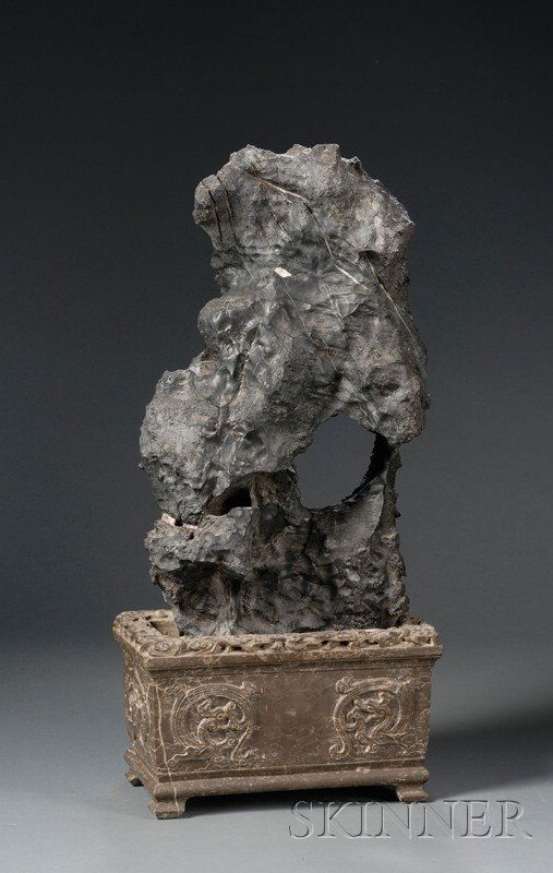 Scholar's Stone and Stand, China, 17th century, Li: Scholar's Stone and Stand, China, 17th century, Ling pi stone of deep black color, carved stone base, rectangular carved with dragons facing a Shou character with clouds around the edge, stone ht. 23,