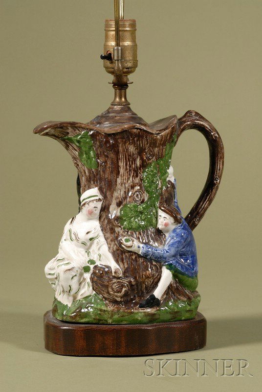 Staffordshire Pottery Fair Hebe Jug, England, 19th: Staffordshire Pottery Fair Hebe Jug, England, 19th century, electrified, after the original modeled by John Voyez, polychrome enamel decorated and molded, the body in a tree trunk form with male and f