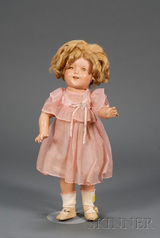 Ideal Composition Shirley Temple Doll, marked Shir: Ideal Composition Shirley Temple Doll, marked Shirley Temple 18, with open mouth, sleeping metal eyes (crazed), blonde mohair wig, five-piece jointed body, period (but not original) ruffled pink organ