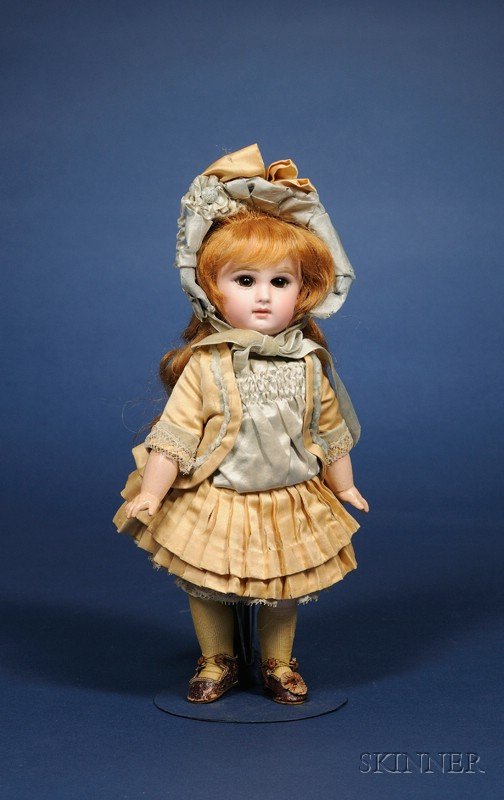Incised Jumeau Bisque Bebe, marked Jumeau 3 and re: Incised Jumeau Bisque Bebe, marked Jumeau 3 and red painter's marks C X II, with closed mouth, outlined lips, fixed amber brown paperweight eyes, feathered brows, pierced ears, long cinnamon mohair wi