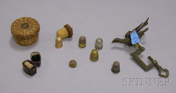 Group of Sewing Implements, six thimbles: two gol: Group of Sewing Implements, six thimbles: two gold, three silver, one brass; a woven acorn-shaped thimble holder, small woven sweetgrass covered basket, and a brass sewing bird with table clamp, brass