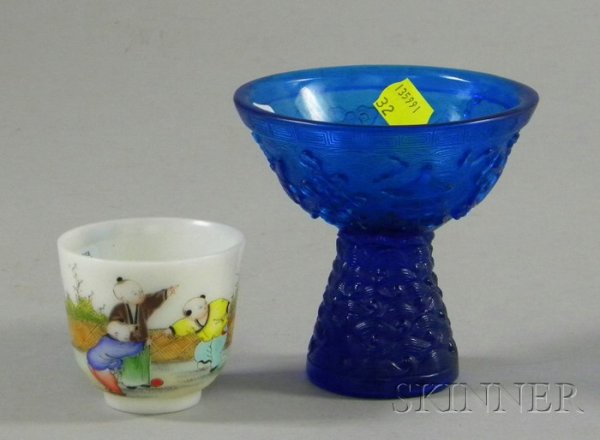 Two Asian Glass Items, a blue footed bowl with flo: Two Asian Glass Items, a blue footed bowl with floral, fish, and urn designs, and a ceramic sake cup depicting children at play, ht. to 4 in.