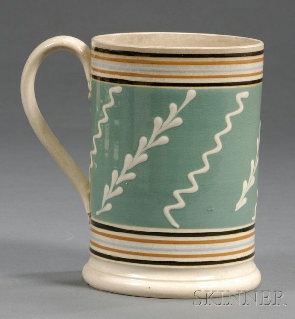 Mochaware Quart Mug, Britain, c. 1830, pearlware m: Mochaware Quart Mug, Britain, c. 1830, pearlware mug ornamented with a wide green band with white slip sprigs and zigzag lines flanked by thin bands of black, rust, and light blue, molded leaf handle