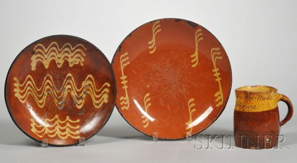 Two Redware Slip Decorated Plates and a Milk Jug,: Two Redware Slip Decorated Plates and a Milk Jug, America, early 19th century, the plates with coggled rims and yellow slip decoration, the milk jug with yellow slip rim band with sgraffito inscriptio