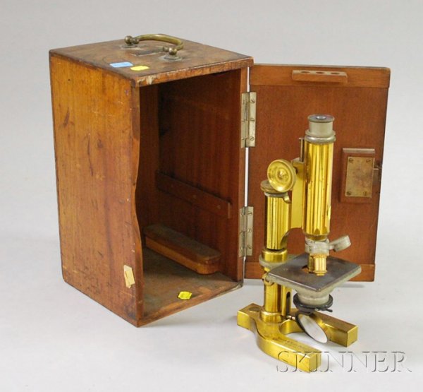 Brass Compound Microscope by Bausch & Lomb Optical: Brass Compound Microscope by Bausch & Lomb Optical Co., Rochester, New York, with U-shaped base signed with maker's name, planar mirror, rack focus, nosepiece with three objectives and walnut carrying