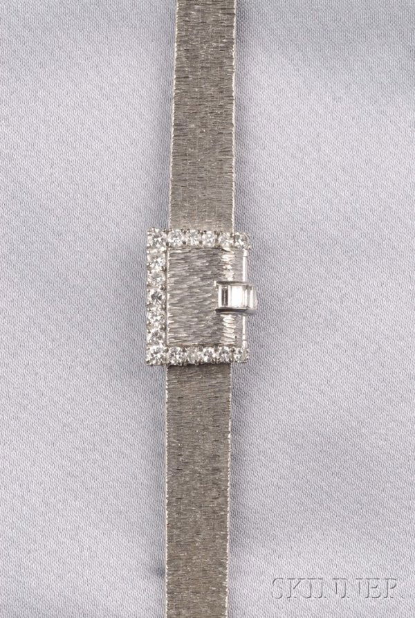 Lady's 18kt White Gold and Diamond Covered Wristwa: Lady's 18kt White Gold and Diamond Covered Wristwatch, Piaget, the silver-tone metal dial with baton numeral indicators, enclosing back-wind movement, concealed by a full and baguette-cut diamond buck