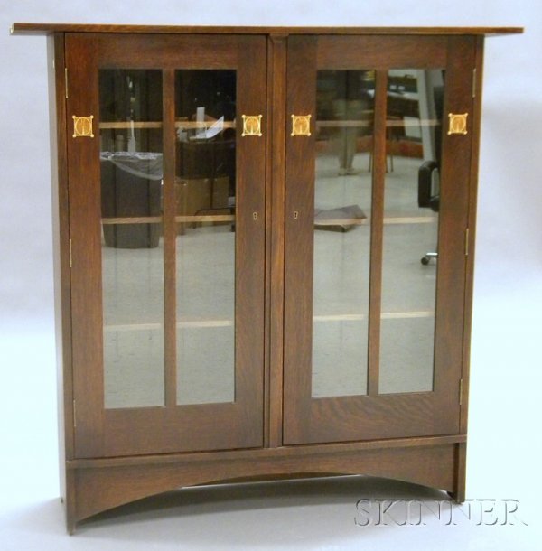 Arts & Crafts Style Inlay Bookcase Oak and light wo: Arts & Crafts Style Inlay Bookcase Oak and light wood inlay Probably L. & J.G. Stickley, Manilus, New York, early 21st century Rectangular top over two doors with vertical mullion accented by four geo