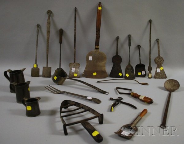 Twenty-one Assorted Metal Kitchen and Hearth Uten: Twenty-one Assorted Metal Kitchen and Hearth Utensils and Ware, including a steel cutter, a trivet, tin dipper, two utensils, three tin measures, sugar cutter, a fork, ten turners, and a skimmer.