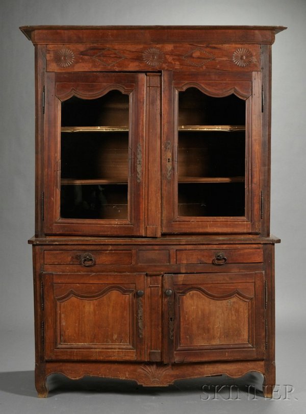 French Provincial Fruitwood Buffet a Deux Corps, : French Provincial Fruitwood Buffet a Deux Corps, 19th century, the upper section with molded cornice above a fan and diamond-carved frieze and a pair of doors enclosing a shelved interior; projecting 