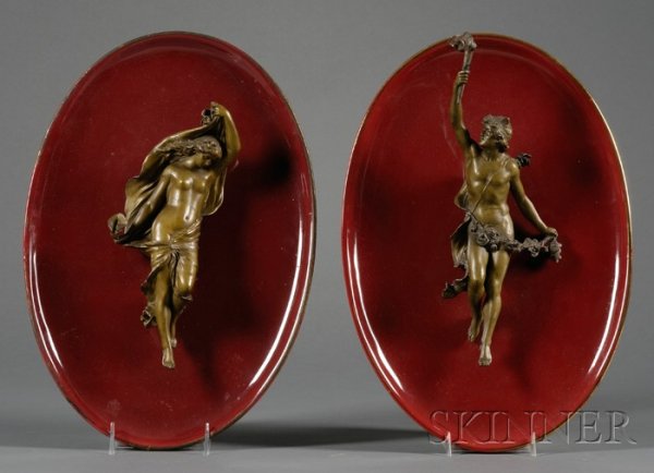 Pair of Red Glazed Earthenware and Bronze Wall Pla: Pair of Red Glazed Earthenware and Bronze Wall Plaques, France, 19th century, oval shaped mounted with classical subjects, traces of gilding to the rims, lg. 16 in.