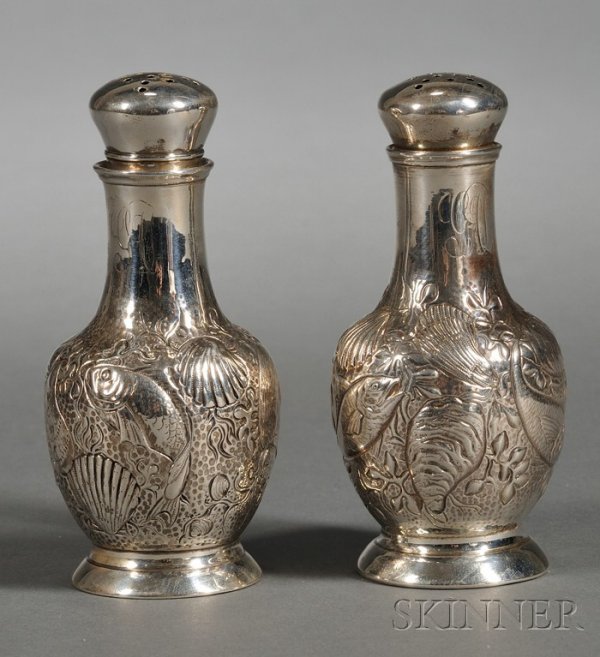 Pair of Gorham Sterling Aesthetic Movement Casters: Pair of Gorham Sterling Aesthetic Movement Casters, 1884, balustroid, chased and embossed at body with fish swimming amidst seashells and seaweed, on flaring base, monogrammed, ht. 4 1/8 in., approx. 