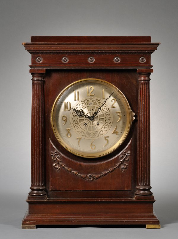 Mahogany "Empire" Mantel Clock by Chelsea, Boston,: Mahogany "Empire" Mantel Clock by Chelsea, Boston, 1909, with flat cornice top, carved neoclassical swag below the dial, pierced brass side sound vents backed with fabric, 3/4 fluted columns flanking 