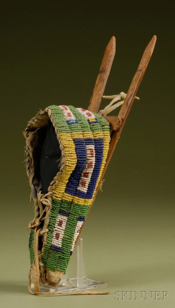 Plains Beaded Hide Miniature Cradle, Cheyenne, c. : Plains Beaded Hide Miniature Cradle, Cheyenne, c. last quarter 19th century, possibly a recycled piece of beadwork, with box and border design on buffalo hide, remnant cloth lining, mounted on boards 