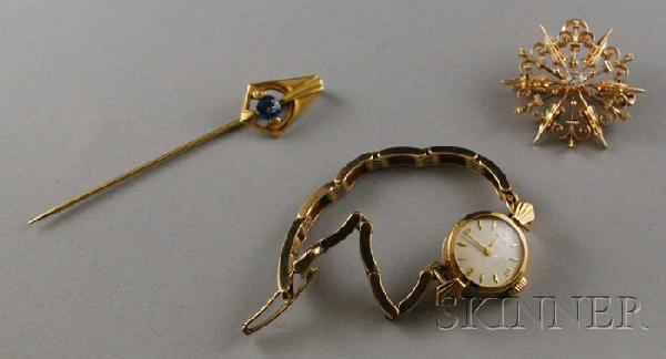 Three Gold Jewelry Items, a 14kt gold and diamond: Three Gold Jewelry Items, a 14kt gold and diamond starburst brooch, a 14kt gold gem-set stickpin, total 5.4 dwt, and a 9kt gold lady's Rolex wristwatch.