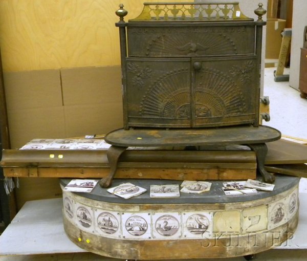 John Conant Brandon Cast Iron Stove on a Gray Sla: John Conant Brandon Cast Iron Stove on a Gray Slate-top Delft Tile-clad D-shaped Base with Wall Panel, mounted with forty tiles, (missing approx. five tiles), approx. stove ht. 33, wd. 33 1/2, dp. 21 