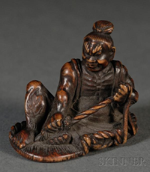 Boxwood Netsuke, Japan, 19th century, carved as a: Boxwood Netsuke, Japan, 19th century, carved as a nio sitting on a big sandal that he is mending, signed "Ju-Kazu," ht. 1 1/2, lg. 1 5/8 in.